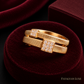 Close-up of Arielle gold-tone double-band square crystal ring on burgundy velvet